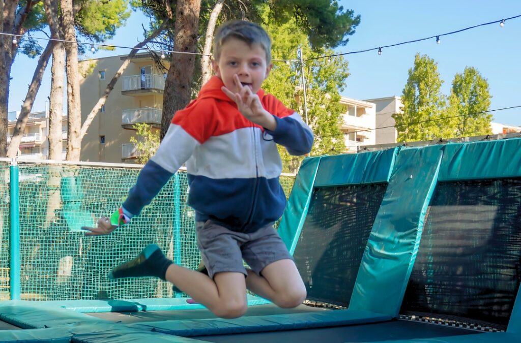 Niño saltando y divirtiéndose en camas elásticas.