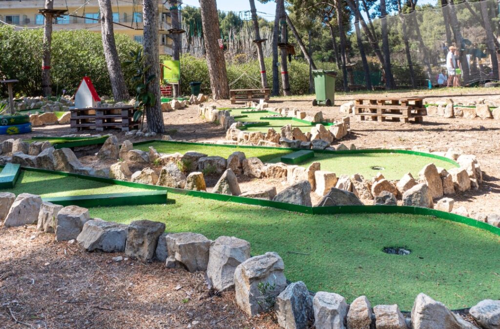 Campo de mini golf con obstáculos y áreas verdes.