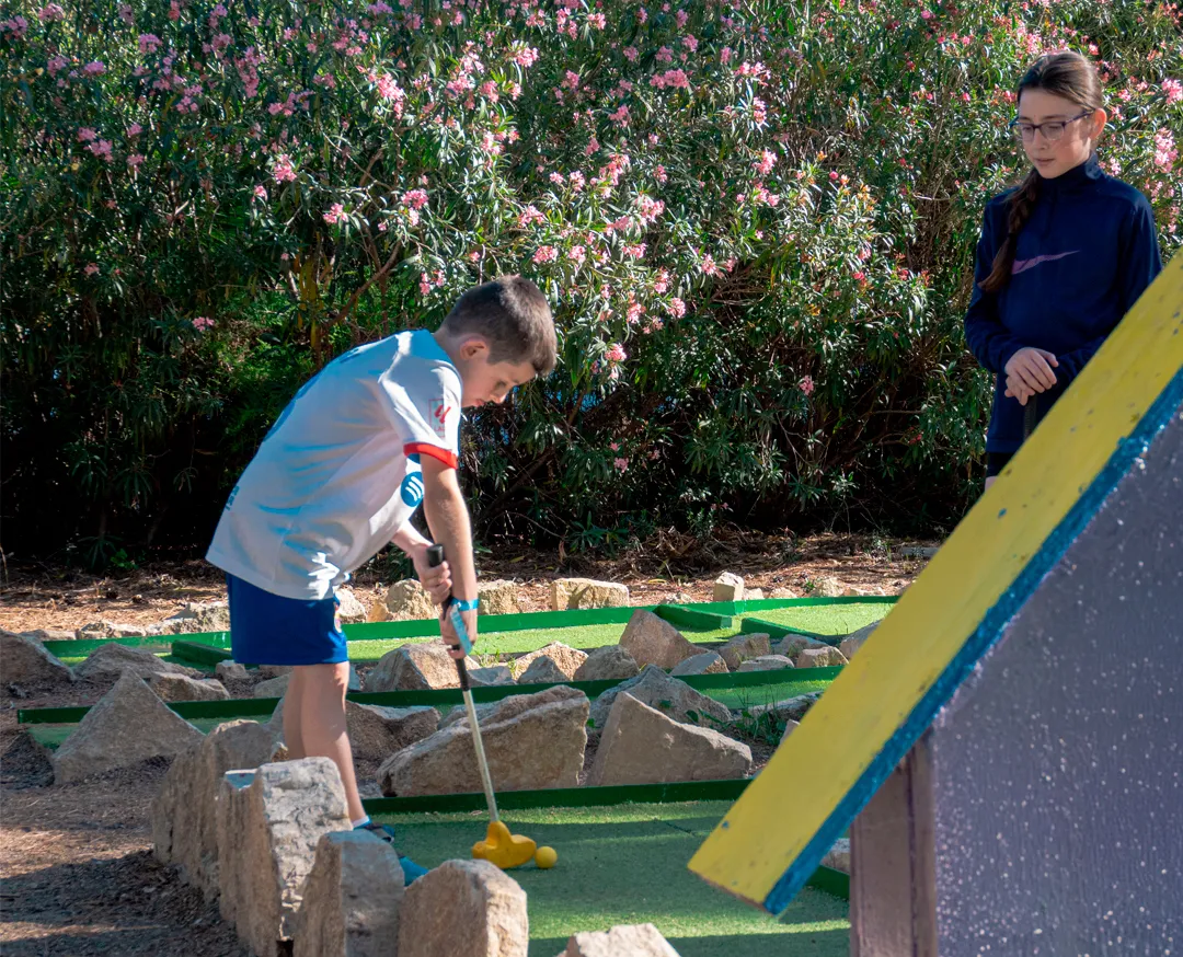 Child playing mini golf obstacle hole at Bosc Aventura Salou mini golf course