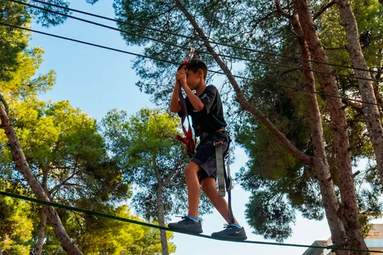 girl crossing zip line obstacle at Bosc Aventura Salou adventure park