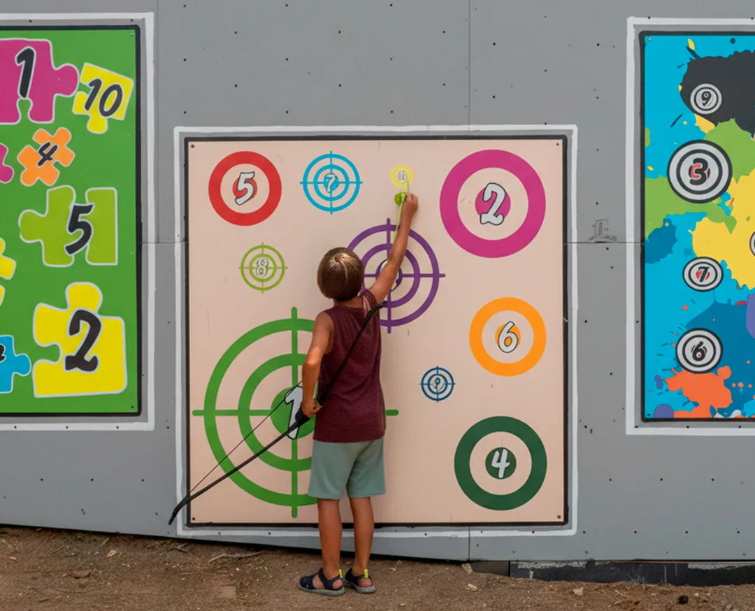 child shooting arrows at target in Salou archery range