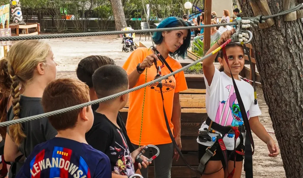 Niños disfrutando del circuito de tirolinas durante un cumpleaños en Bosc Aventura Salou